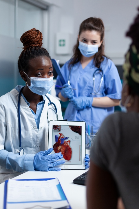 African american cardiologist doctor holding tablet showing heart radiography business 01-1000